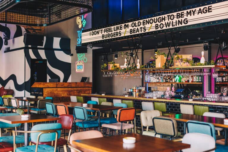 Bar with neon slogan sign and colourful seating at The Central Yas Bay, Abu Dhabi