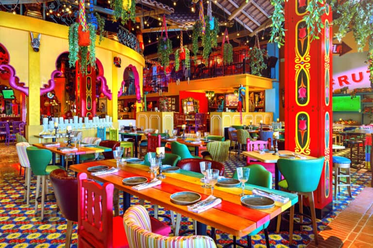 Colourful dining room with tiled floor, hanging plants and red columns at En Fuego, Atlantis The Palm