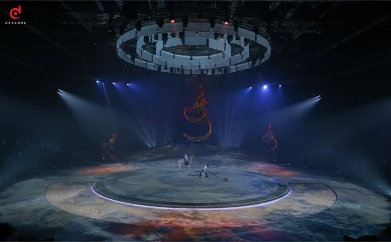 Circular stage under a ring of lighting and a suspended chandelier, TERHAL by Dragone, Diriyah
